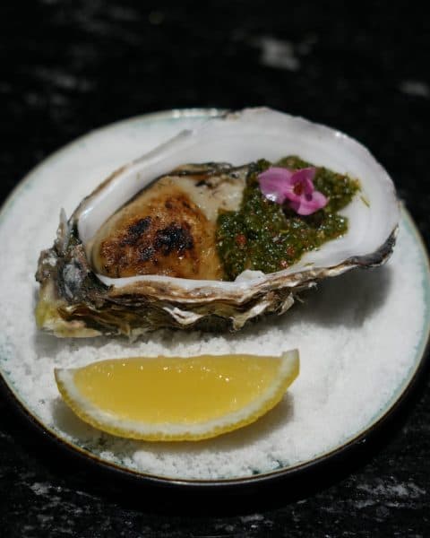 Grilled oyster with herb salsa at Carbon